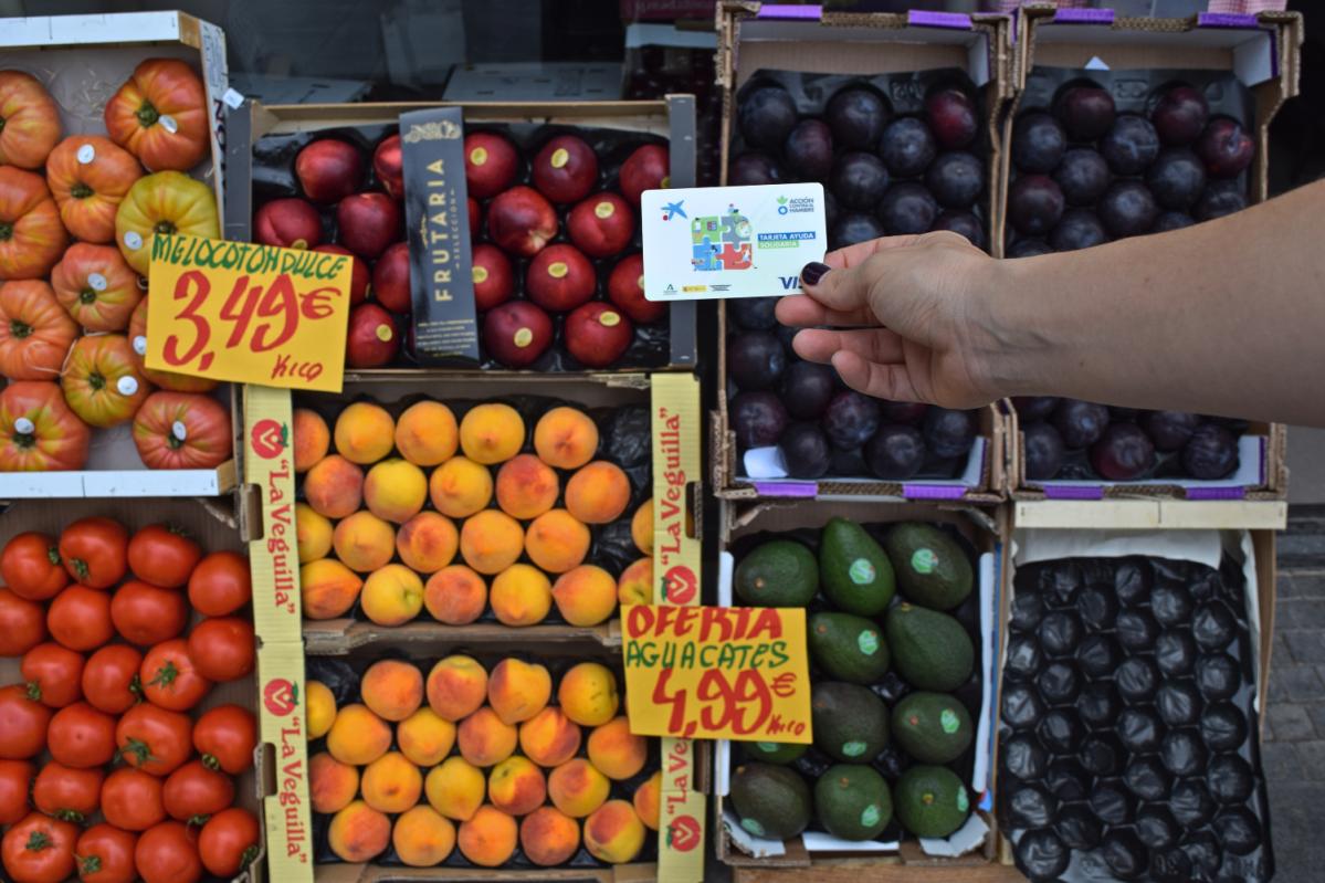 Mano con una tarjeta de ayuda solidaria para combatir la inseguridad alimentaria en España - Acción contra el Hambre - 4 retos