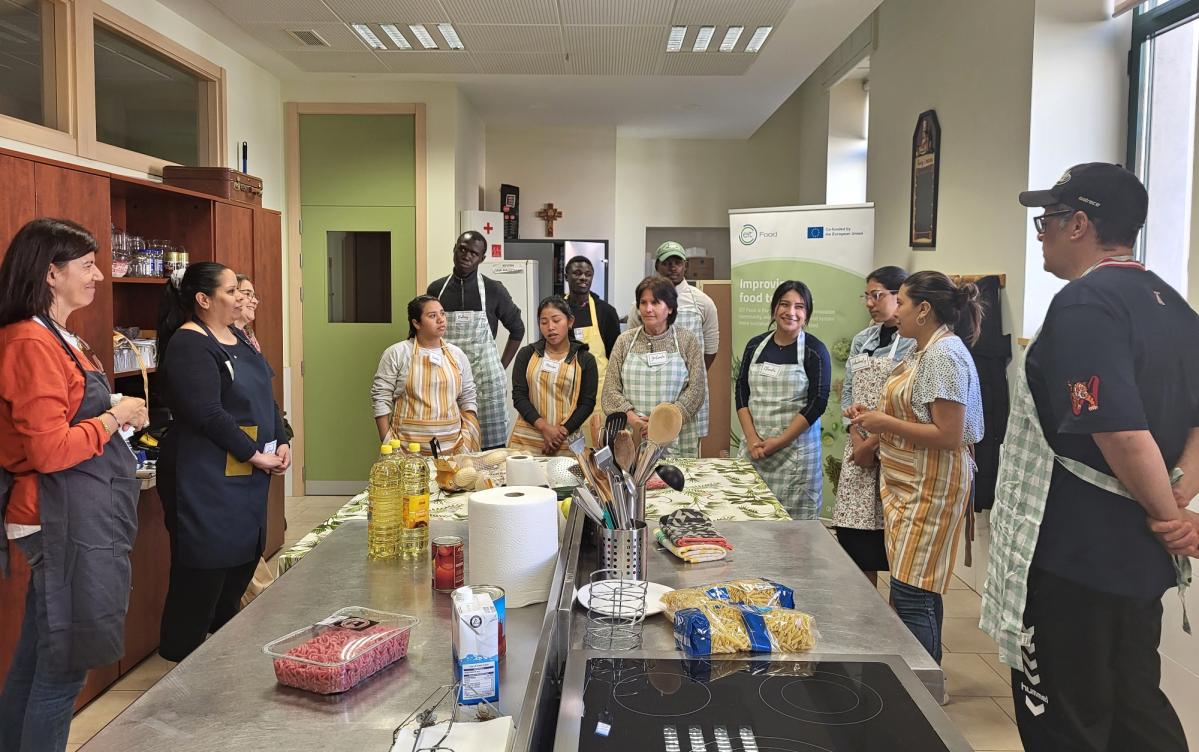 Personas participantes Ample Madrid recibiendo una clase de cocina - Programas empleo Acción contra el Hambre