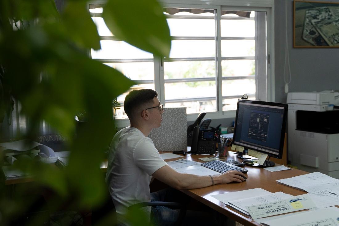Chico Joven en su centro de trabajo con un ordenador - Programas de empleo para jóvenes - Vives Emplea - Acción contra el Hambre - Extremadura